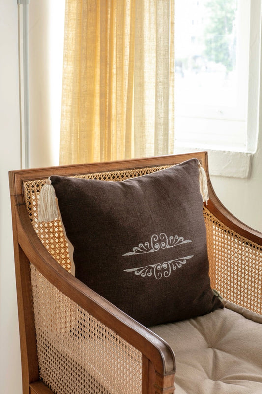 Brown Block print cushion cover on wooden armchair 