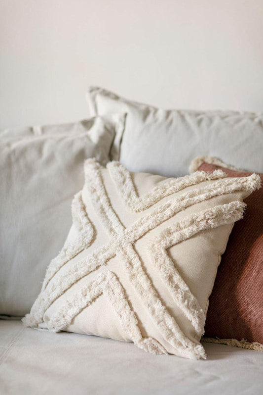 Close-up of beige boho chic cushion cover with textured cotton stitching on white sofa