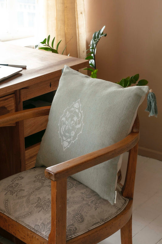 mint green blockprint cushion cover on wooden armchair near desk close up